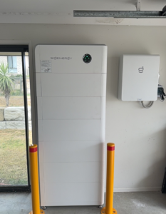 A Sigenergy battery and inverter in a garage beside bollards