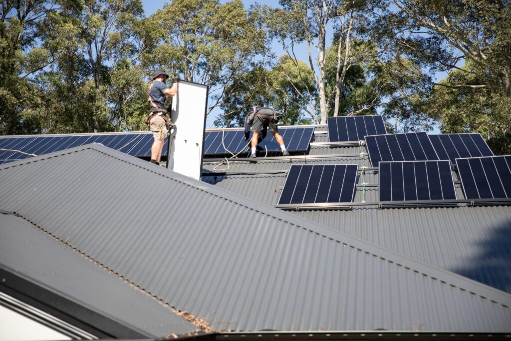 Two installers working along a roof ridge, Coffs Harbour & the Clarence