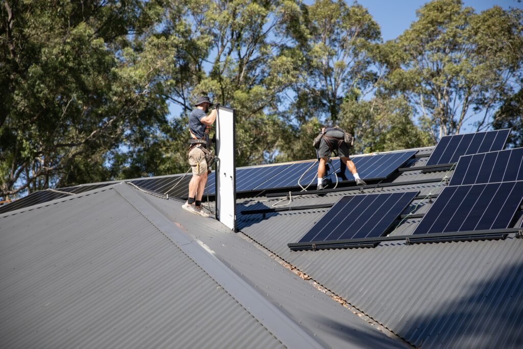 An installer lifting a panel into position on a roof, the Gold Coast