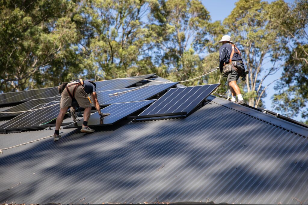 Two Clean Power installers fitting solar panels on a suburban roof, South Australia
