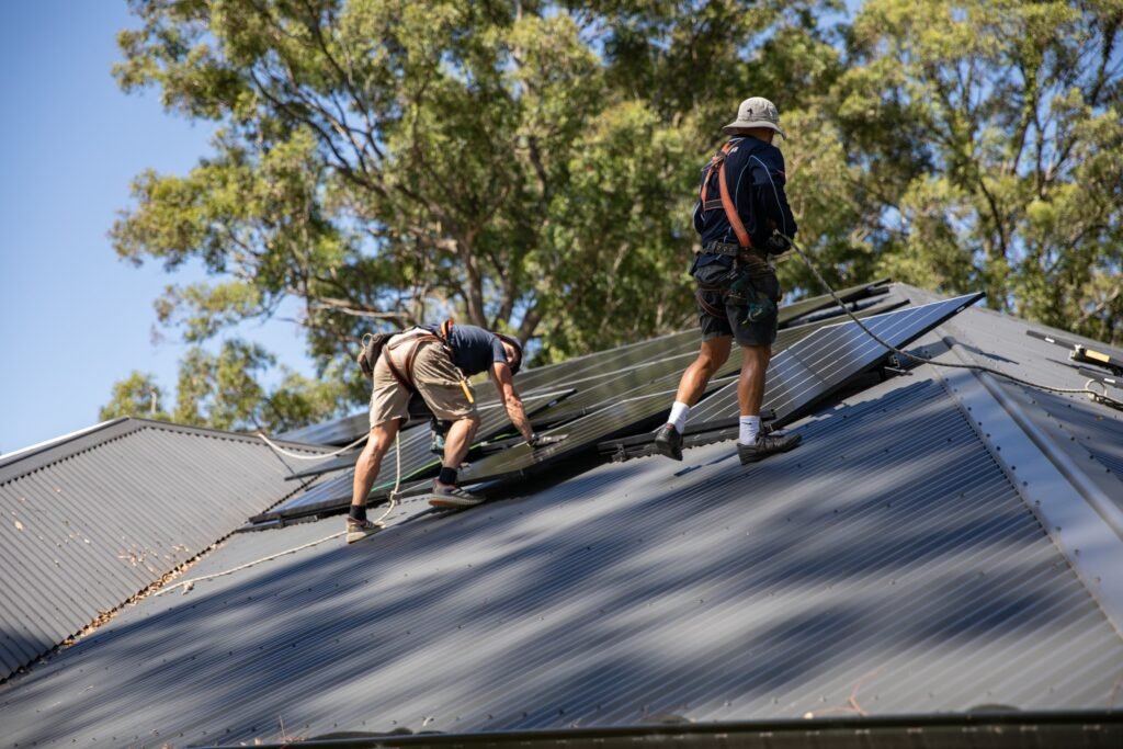 An installer kneeling to fix a panel into place, Canberra & the ACT