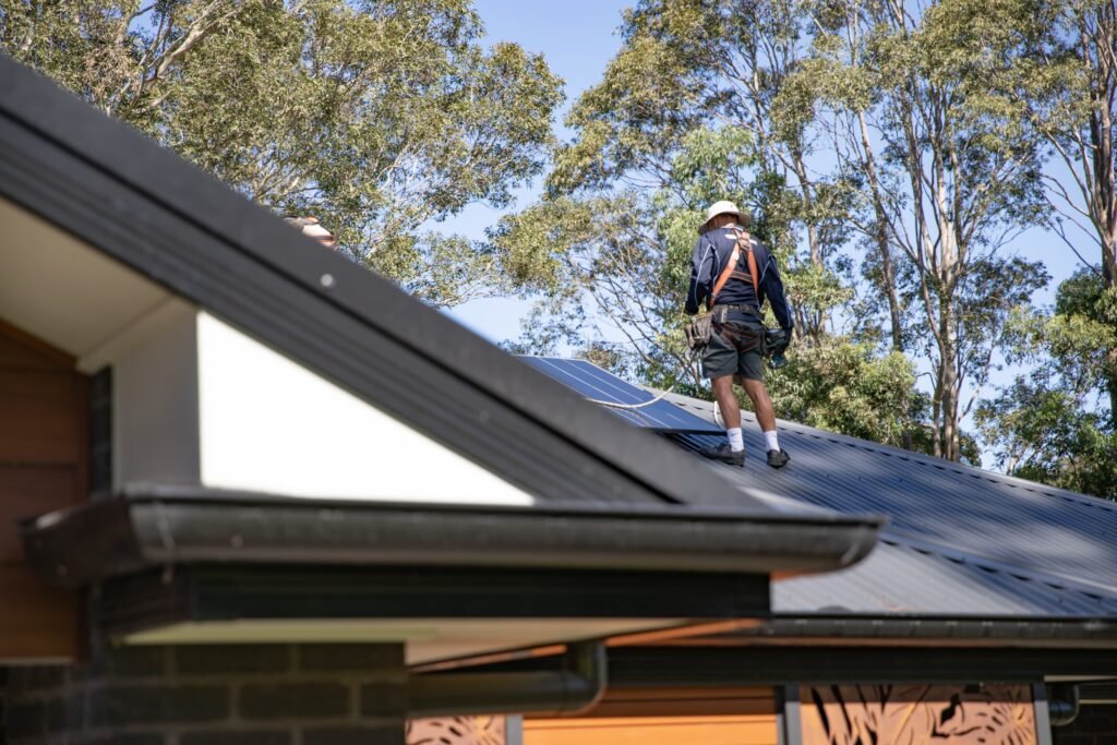 An installer moving panels across a metal roof, Adelaide