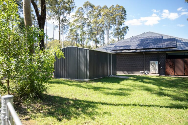 A brick house with rooftop solar seen across a lawn