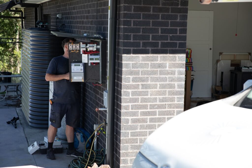 An installer working at a garage-mounted battery, the Gold Coast