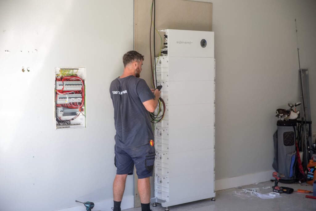 An installer commissioning a floor-standing battery, the Mid North Coast