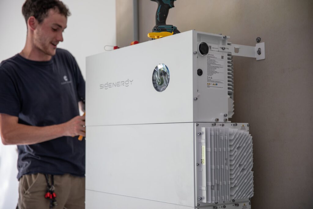 A Clean Power installer fitting a Sigenergy battery, as the rebate factor is set by the installation date