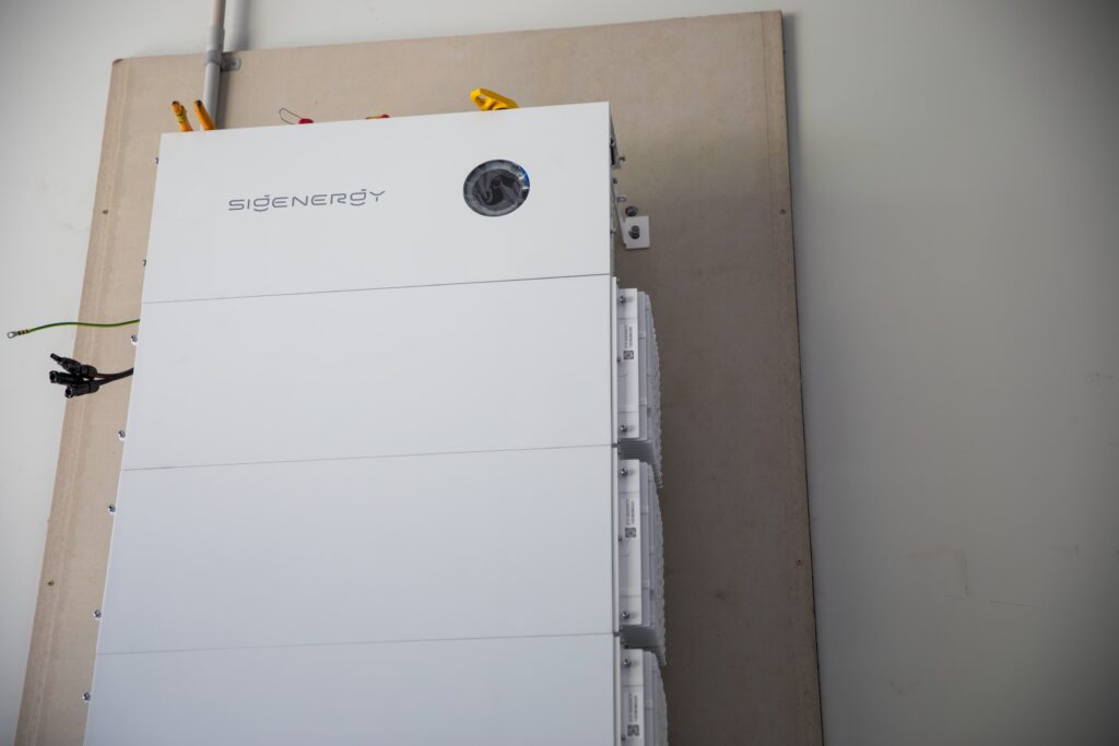 A Sigenergy SigenStor battery installed on a garage wall, ready to cover evening cooling
