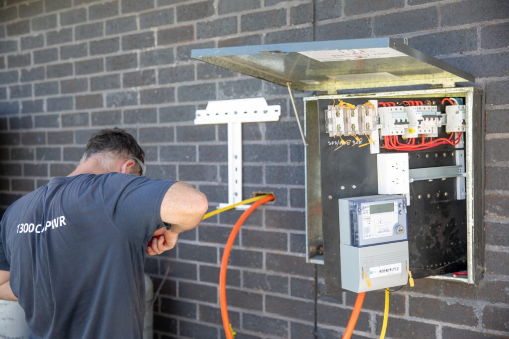 An installer connecting a meter box and switchboard, Coffs Harbour & the Clarence