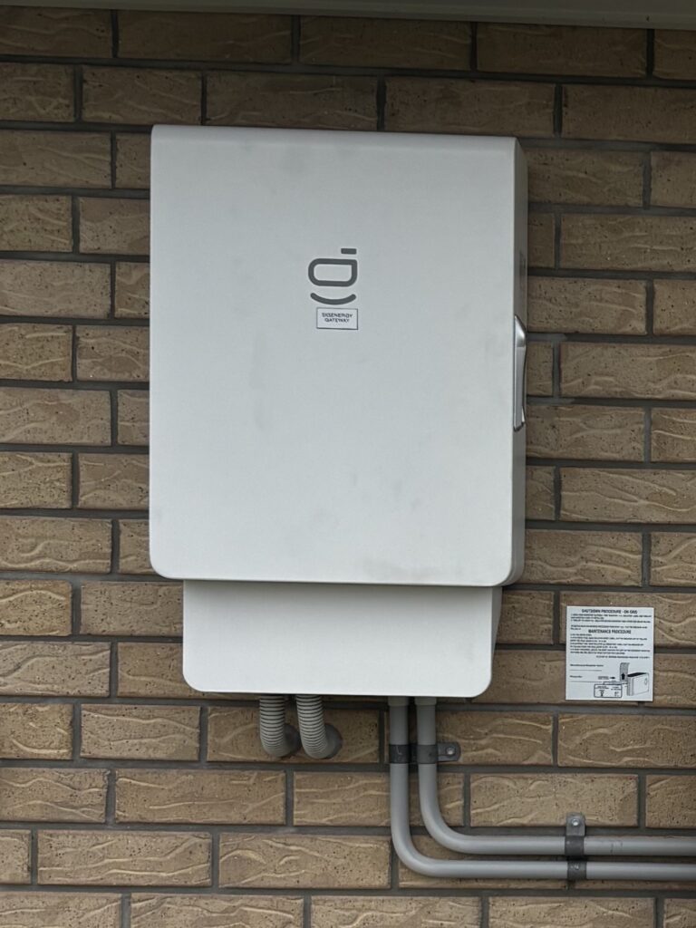 A Sigen Energy Gateway installed on a brick wall, the unit a Sigenergy battery needs for blackout backup